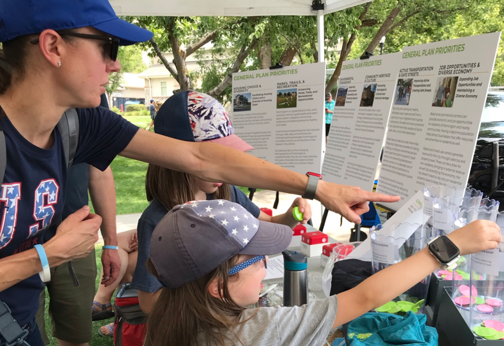 Family providing input on general plan priorities by placing stickers on preferred uses