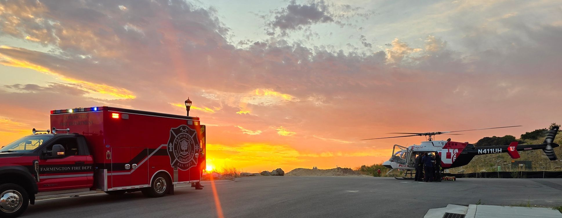 Fire truck and rescue helicopter in sunset